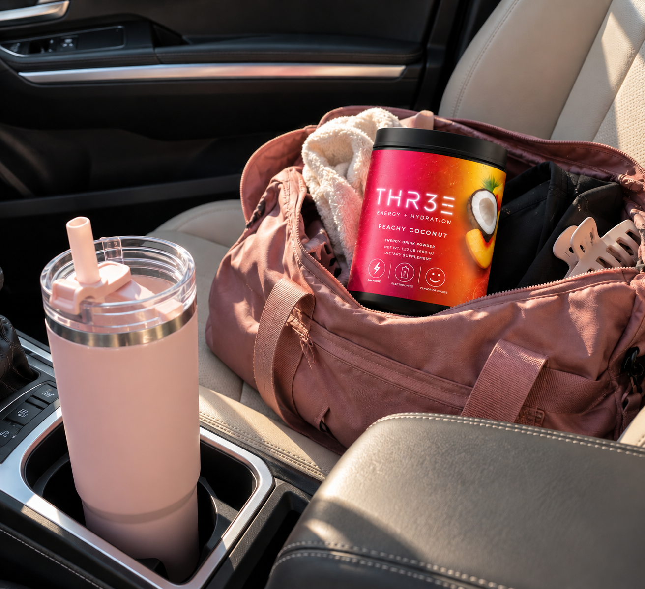 THR3E Peachy Coconut tub in a gym bag next to a pink tumbler in a car cup holder
